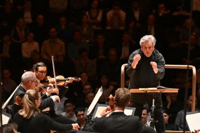 A concert scene with a conductor, Sir Antonio Pappano on the right, sans baton.