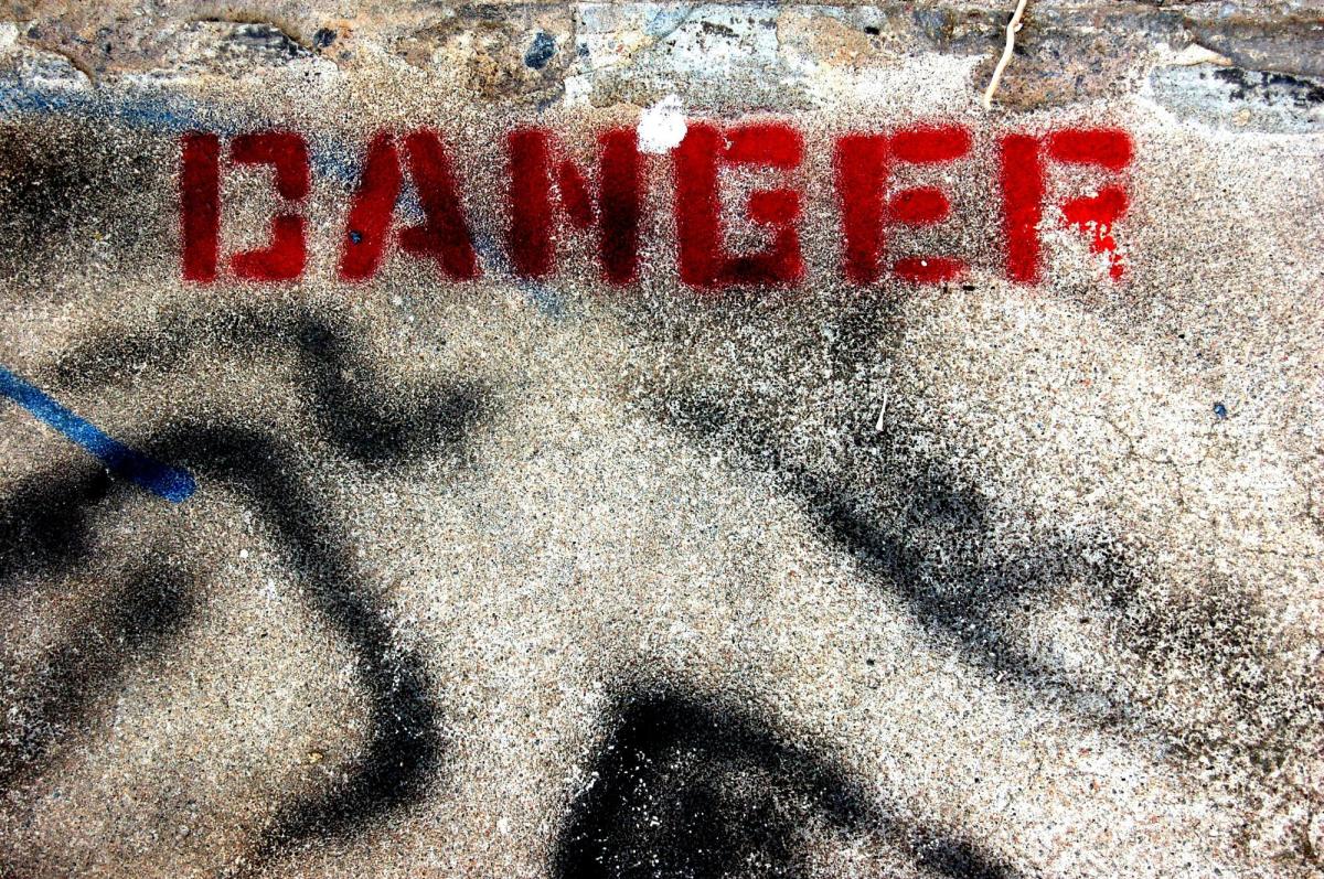 The word "DANGER" is spraypainted in red on the ground. vanity publishers