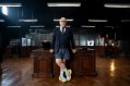 man with grey beard leaning on desk, wearing suit on top and boxer shorts and joggers below. Mental health Brian Cox