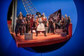 The cast of 'The Pirates of Penzance' aboard a ship, with rigging.