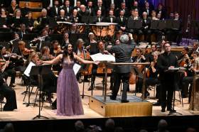 The London Symphony Orchestra with a singer in a violet gown.