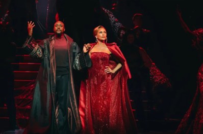 A man, Matt Henry, in fancy black robes, and a woman, Vanessa Willimas in an elegant red formal dress in 'A Devil Wears Prada.'