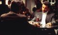 two images one on top of the other of two middle aged Italian men sitting across a diner table looking at each other seriously, over the ketchup and other condiments. Al Pacino is the policeman, Robert De Niro the crook. Heat.